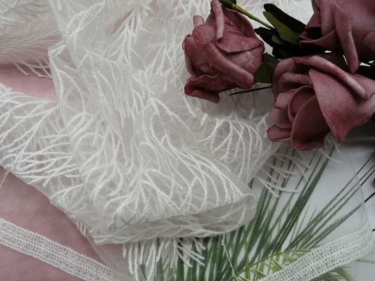 刺繍はレースの生地の白い結婚のレースの生地を束ねた