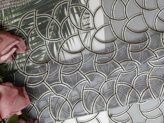 カット・ワークの幾何学的な刺繍されたレースの生地上の灰色すべて
