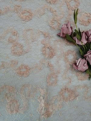 かぎ針編みのきらめきのテュルのピンクの花の網の輝いたレースの生地