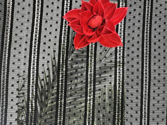 網によってプリーツをつけられた点の刺繍はレースの生地を縞で飾った