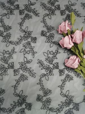 黒いレースの生地の銀のテュルの網をくまなく花によって束ねられる刺繍