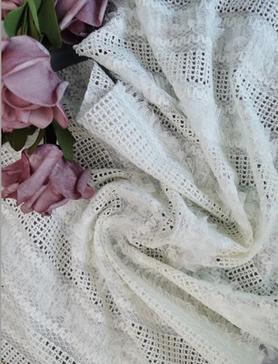 白い花嫁の刺繍されたレースの生地の優雅な婚礼衣裳の服の生地