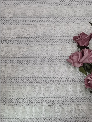 白い刺繍のレースの生地のウェディング ドレスはフランスのレースの生地をひもで締める