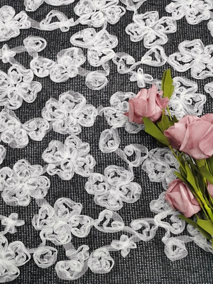 白く黒い対照色の花によって刺繍されるレースの生地のアップリケ