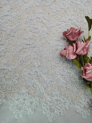 青いかぎ針編みのレースの生地の金属束ねるテュルの刺繍の女性は生地に服を着せる